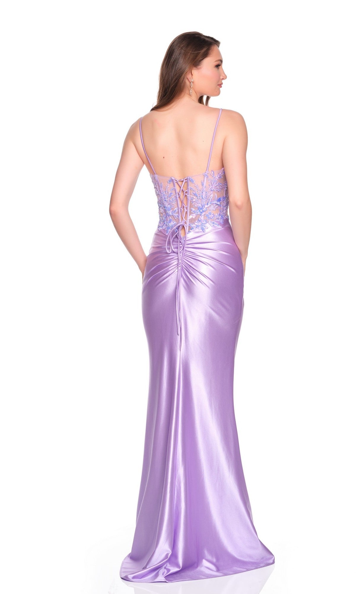 A woman faces away, wearing the Dave and Johnny 12673 long prom dress—featuring shiny purple fabric, spaghetti straps, an embroidered corset bodice, and a satin sheath skirt draping elegantly to the floor.